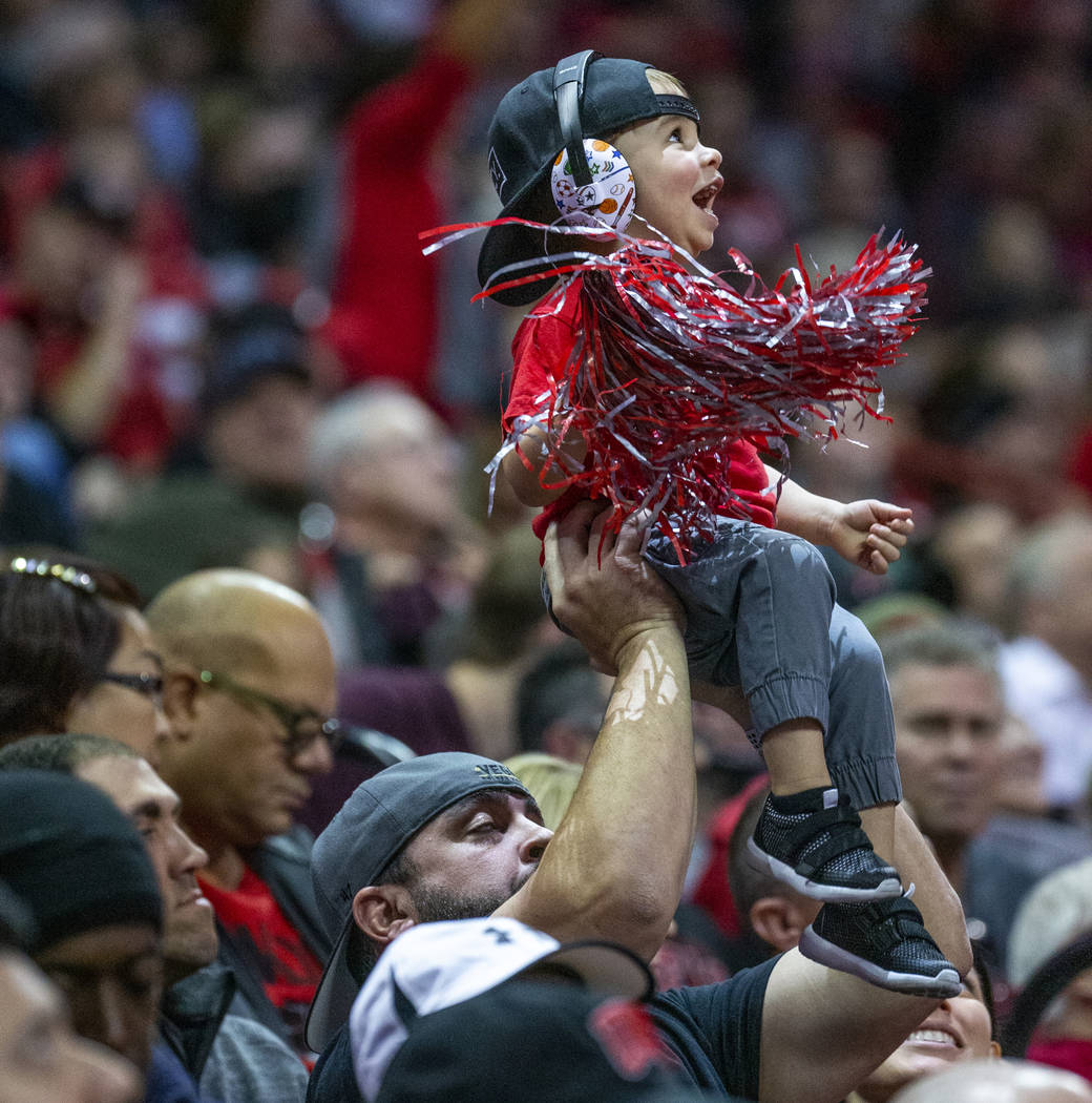 A young UNLV Rebels fan is hoisted up while cheering for the team versus the San Diego State Az ...