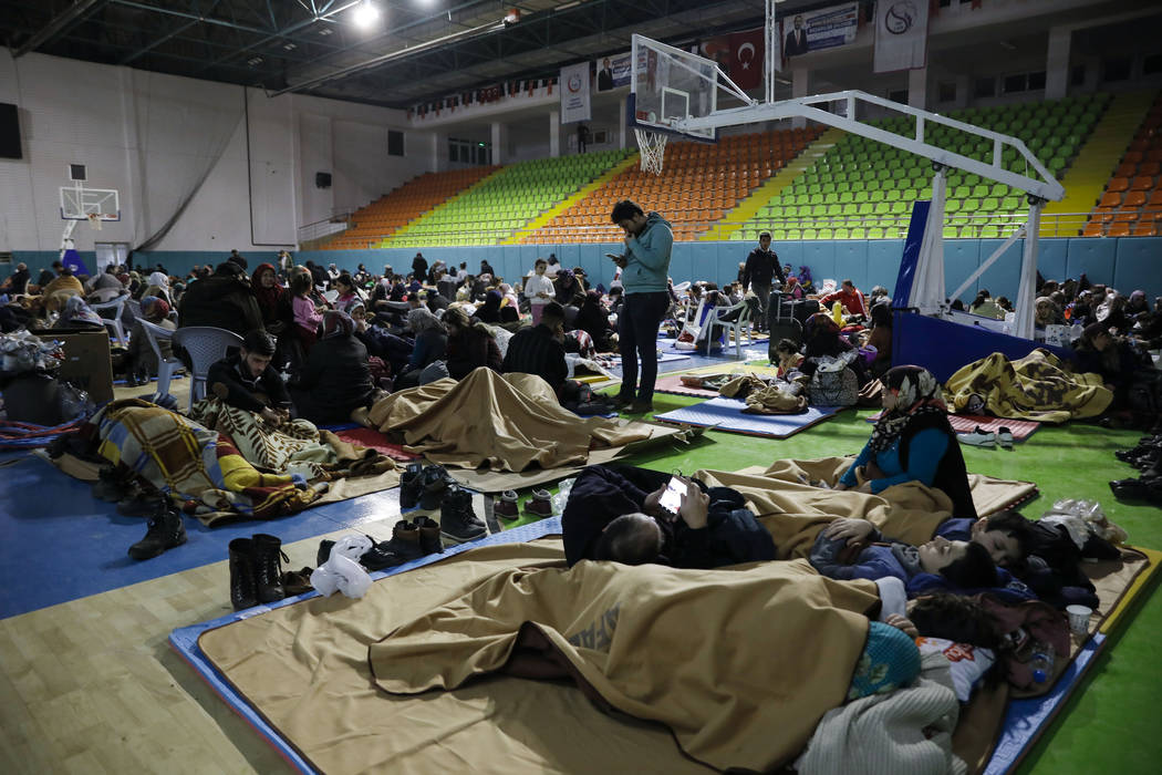 People gather inside a sports hall to spend the night following Friday's earthquake that destro ...