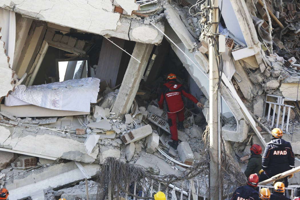 Rescuers work on searching for people buried under the rubble on a collapsed building, after an ...