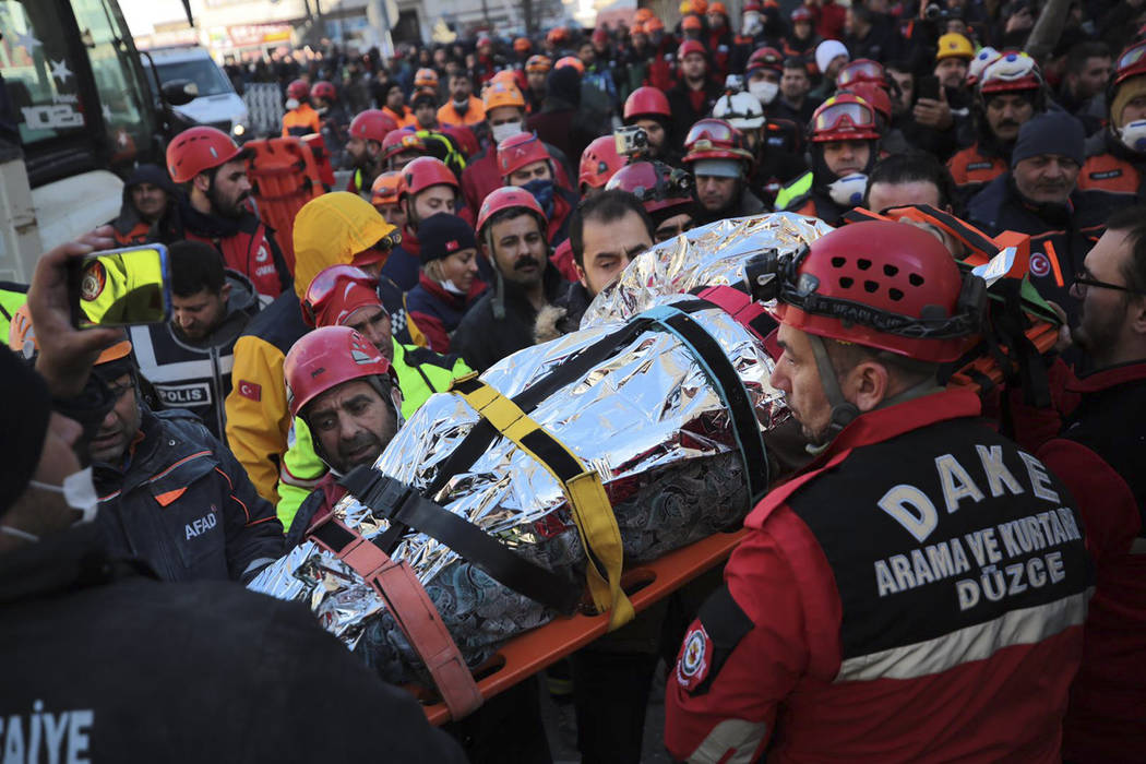 Members of rescue services carry a wounded man, that was found in the rubble of a building dest ...