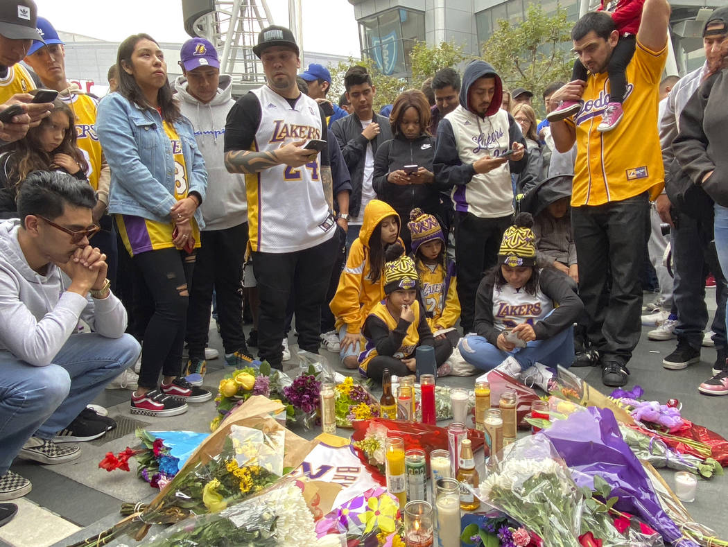 Fan gather around make shift memorials as they mourn the loss of Kobe Bryant in front of La Liv ...