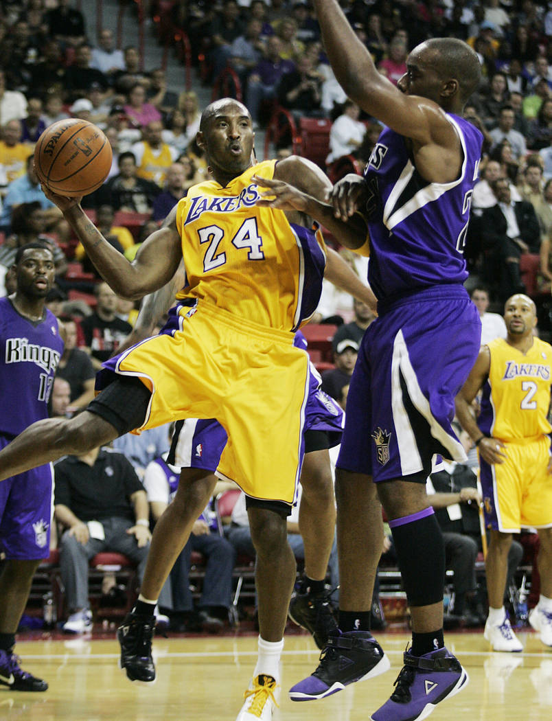 Los Angeles Lakers basketball star Kobe Bryant (24) looks to pass around Sacramento Kings playe ...
