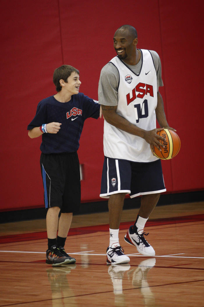 2012 USA Basketball Men's National Team player Kobe Bryan, right, shoots with a young man durin ...