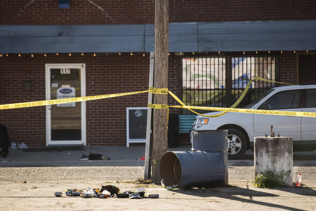 Crime scene tape stretches in front of Mac's Lounge, the scene of an early morning bar shooting ...