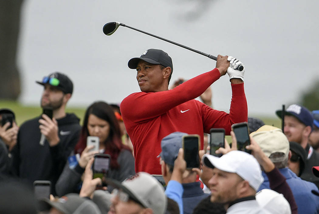Tiger Woods watches his tee shot on the second hole of the South Course at Torrey Pines Golf Co ...