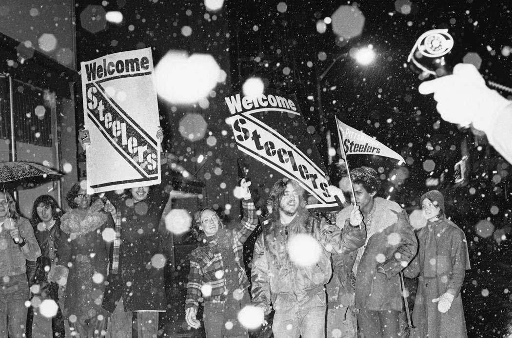 Pittsburgh Steeler fans march through downtown Pittsburgh waving Steeler signs celebrating the ...