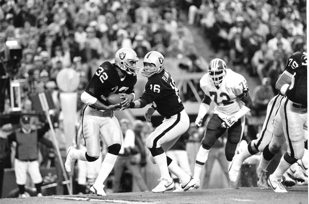 Los Angeles Raiders running back Marcus Allen (32) takes a hand-off from quarterback Jim Plunke ...