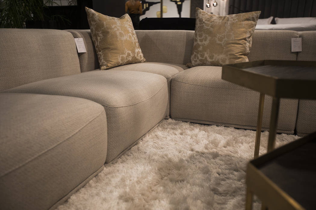 Neutral textures of the couches and rug show a coming trend for the year at the Sunpan booth at ...