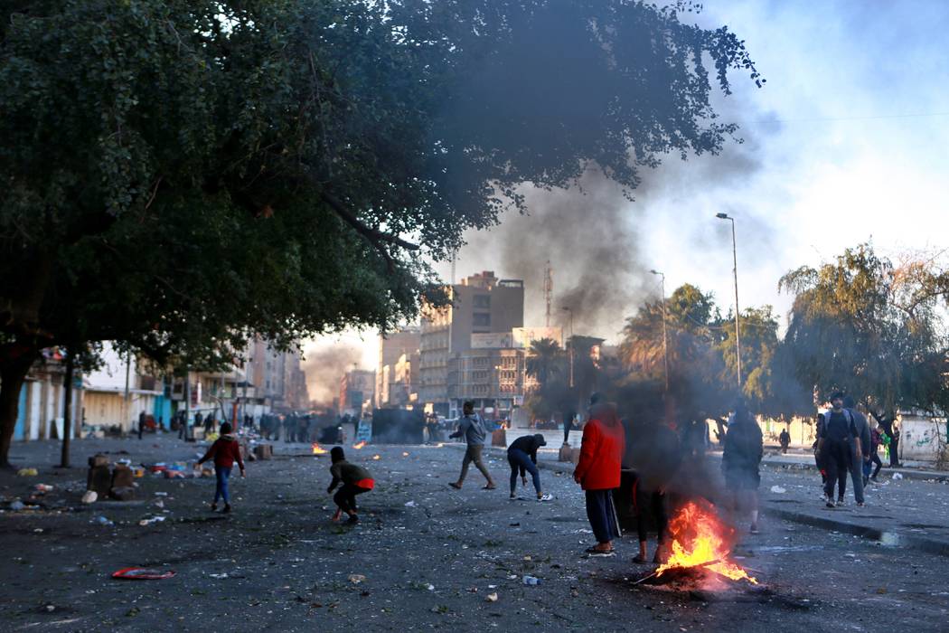 Protesters set fire to close a street during clashes between security forces and anti-governmen ...