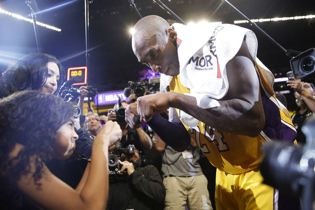 FILE - In this April 13, 2016 file photo Los Angeles Lakers' Kobe Bryant, right, fist-bumps his ...