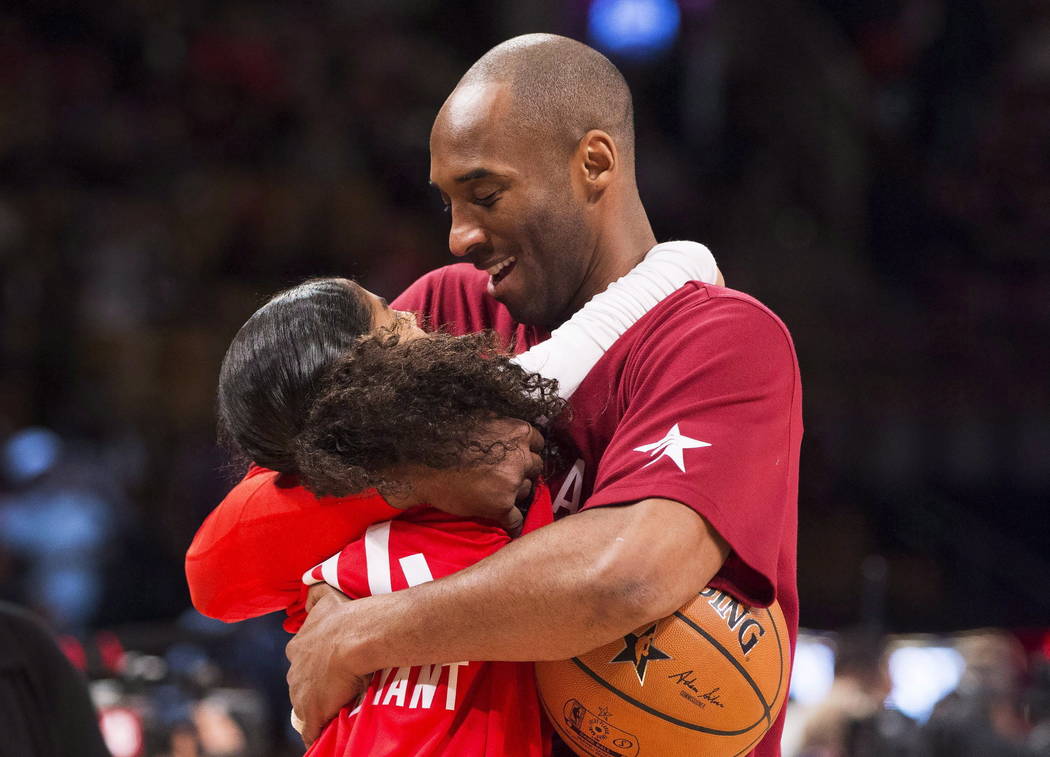 In this Feb. 14, 2016, file photo, Los Angeles Lakers Kobe Bryant (24) hugs his daughter Gianna ...