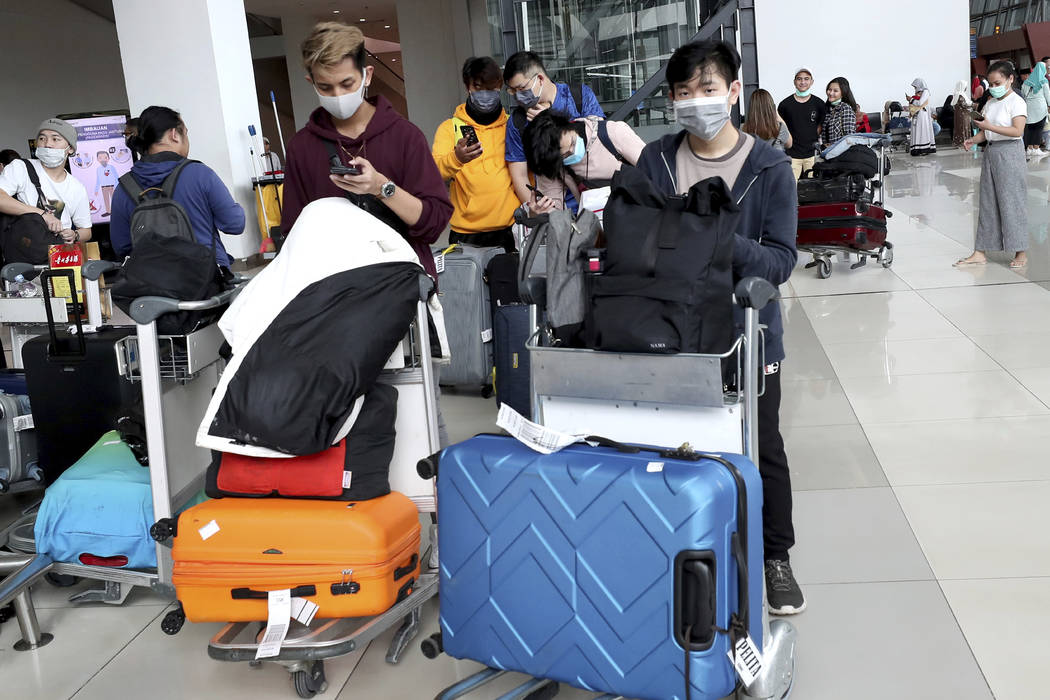 Indonesia students wear face masks as they arrive from Guangzhou, China, at Soekarno-Hatta Inte ...
