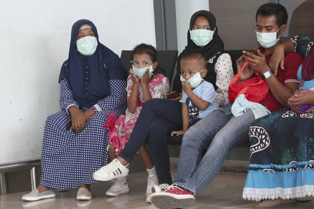 People wear face masks at the arrival gate of the Soekarno-Hatta International Airport in Tange ...