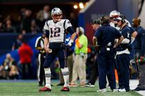 New England Patriots quarterback Tom Brady (12) talks to head coach Bill Belichick on the sidel ...