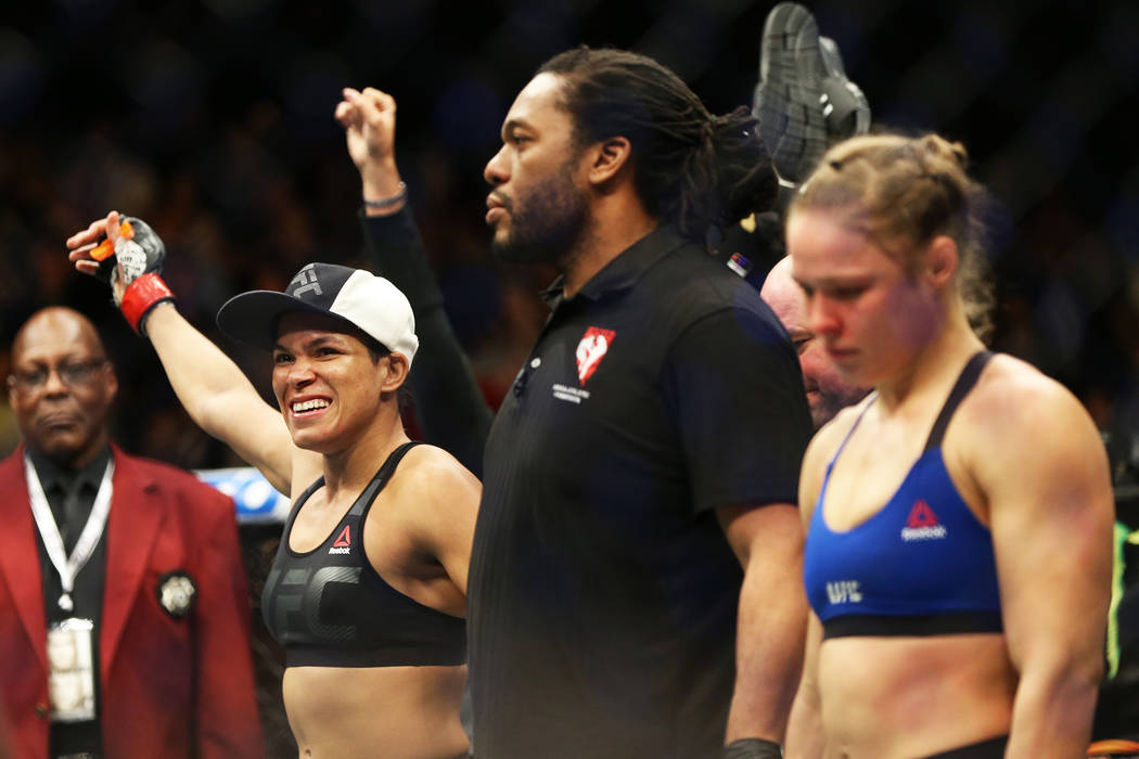 Amanda Nunes, left, celebrates after defeating Ronda Rousey by TKO in the first round during th ...
