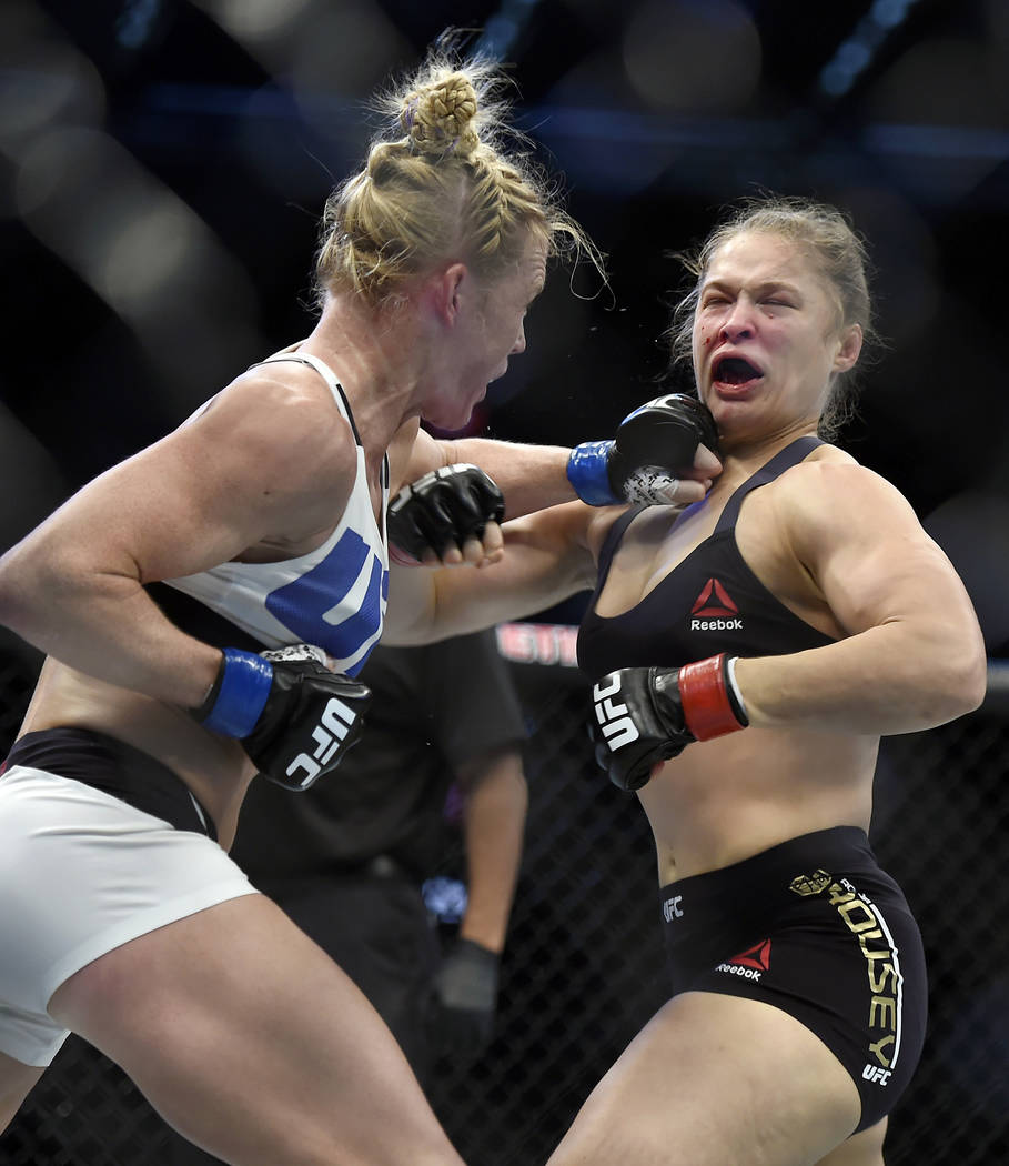In this Nov. 15, 2015, file photo, Holly Holm, left, punches Ronda Rousey during their UFC 193 ...