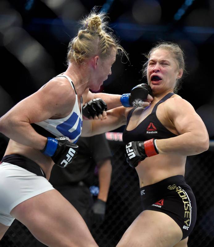 In this Nov. 15, 2015, file photo, Holly Holm, left, punches Ronda Rousey during their UFC 193 ...