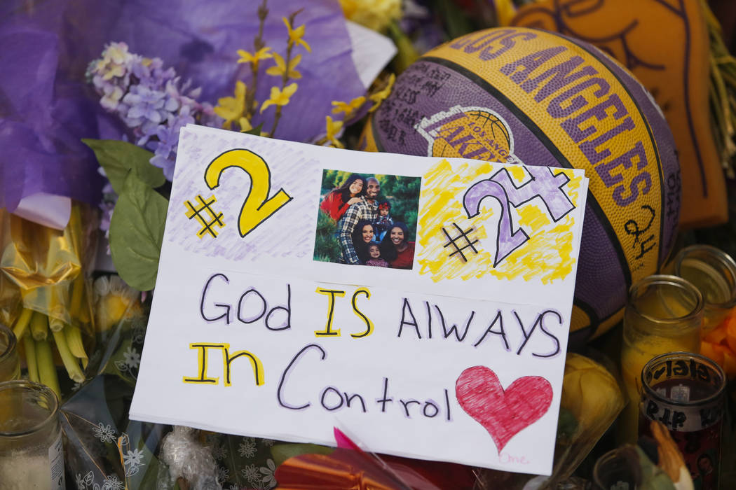 Flowers, basketballs, sweat shirts, candles and message notes are placed at a memorial for the ...