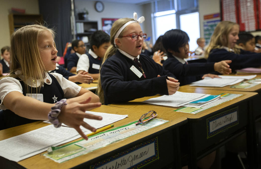 Charlotte Jensen, left, and Olivia Gough, center, both fifth graders, practice spelling during ...