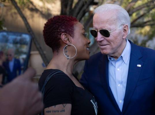 Jasmin Johnston speaks into presidential candidate Joe Biden's ear before posing for a photo wi ...