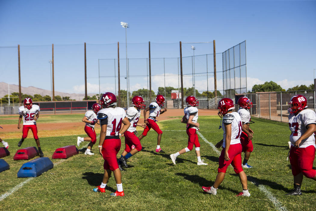 Players run through drills during footballl practice at the baseball field at Valley High Schoo ...