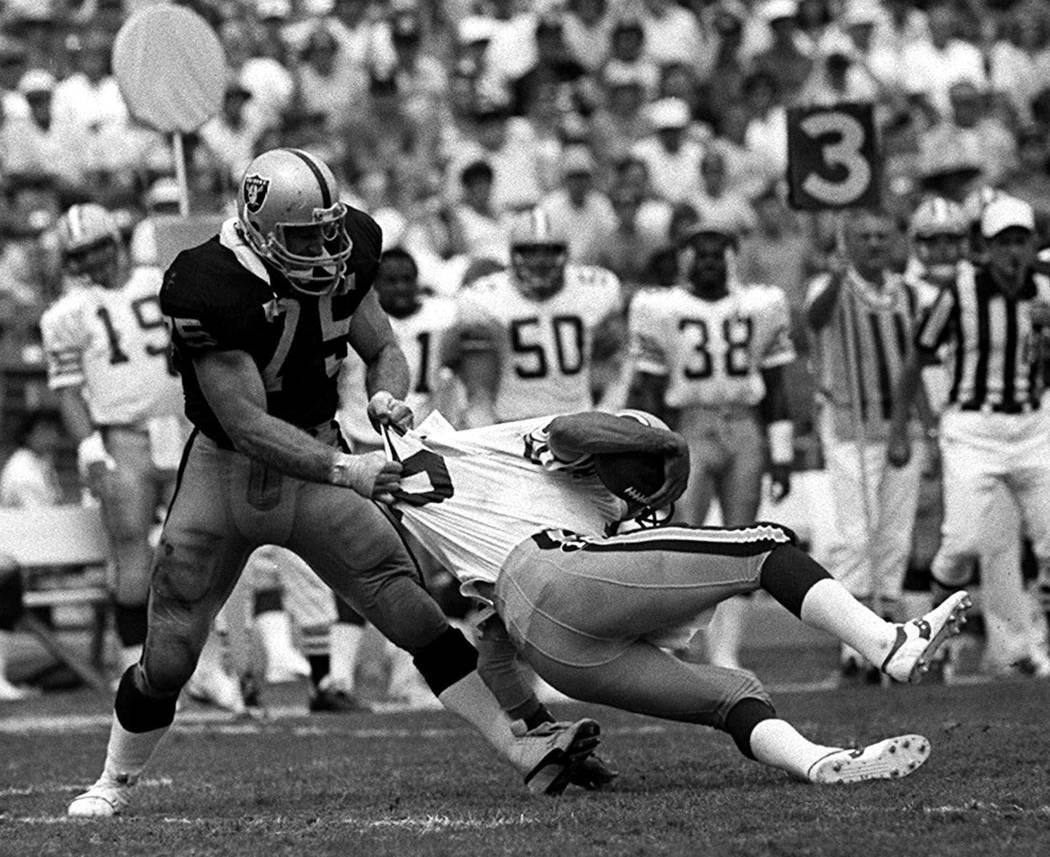 Los Angeles Raiders' Howie Long (75) takes down Green Bay Packers Randy Wright in Los Angeles, ...