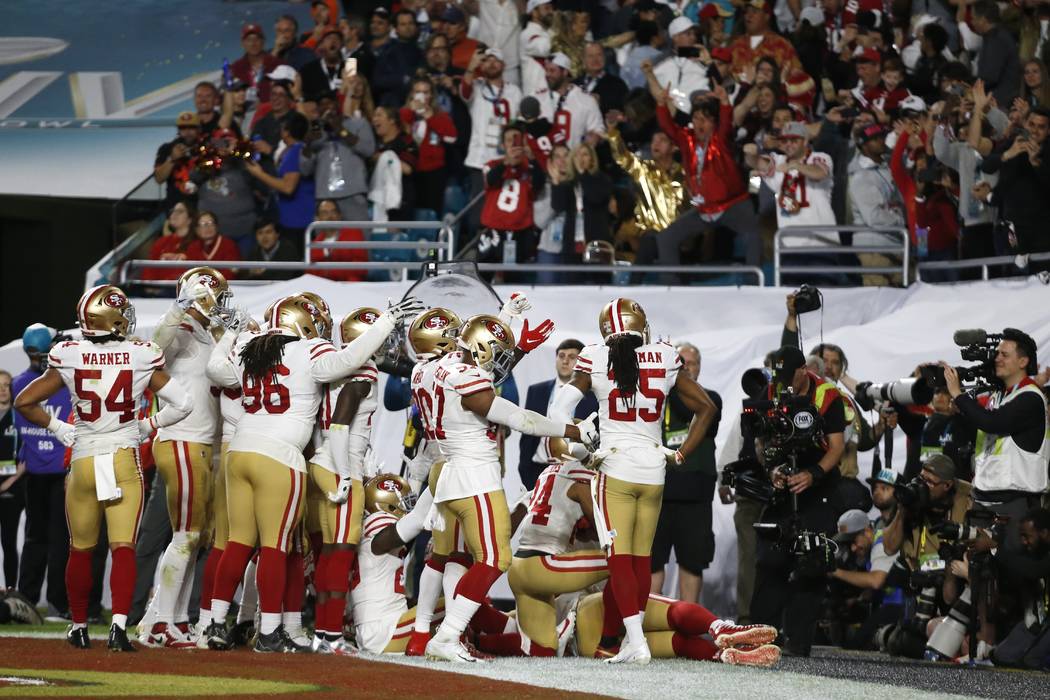 San Francisco 49ers players celebrate after Tarvarius Moore intercepted a pass against the Kans ...