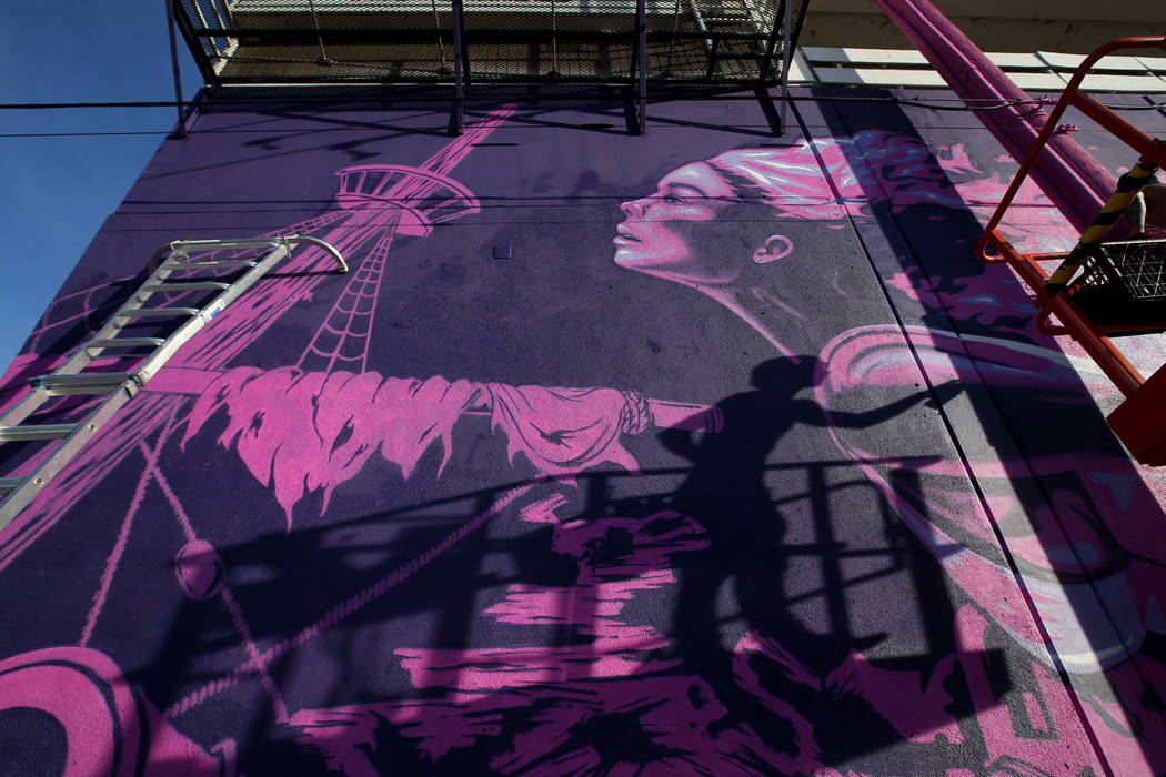 Unidentified crew members paint the mural "Mermaids Don't Wear Skirts," a collaborati ...