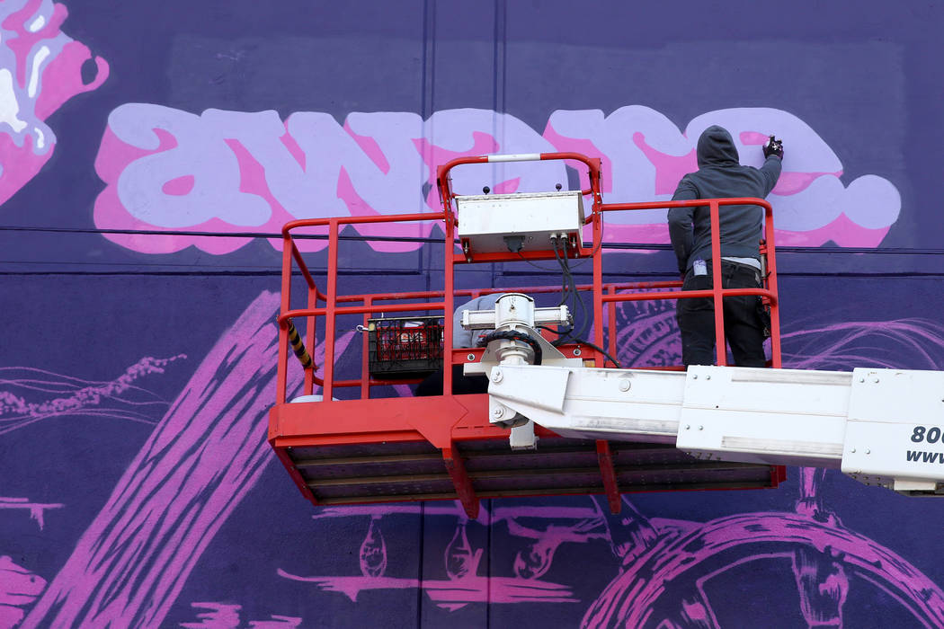 Unidentified crew members paint the mural "Mermaids Don't Wear Skirts," a collaborati ...