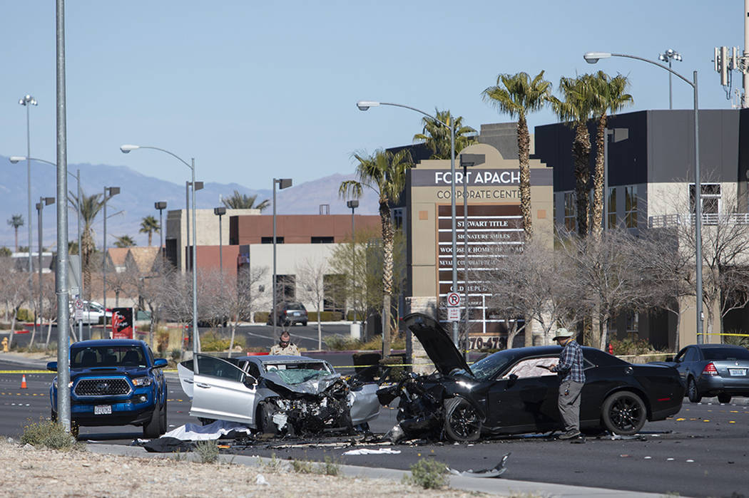 Investigators work at the scene of a fatal collision at the intersection of South Fort Apache ...