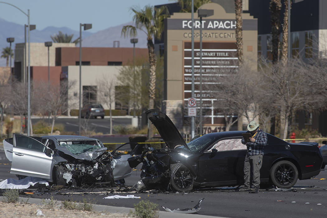 Investigators work at the scene of a fatal collision at the intersection of South Fort Apache ...