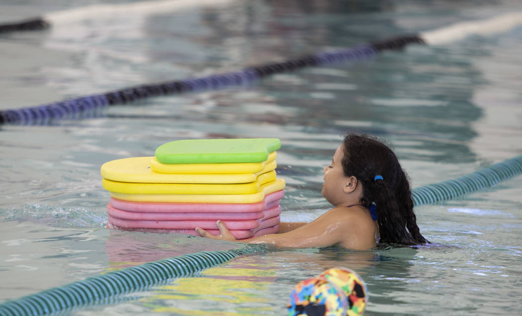 Aurora Sarnessar, 7, gathers kick boards as the Heritage Park Aquatic Complex nears closing tim ...