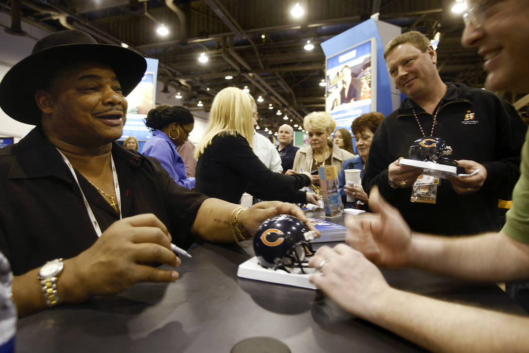 Former NFL football player with the Chicago Bear William 'The Refrigerator' Perry, left, signs ...