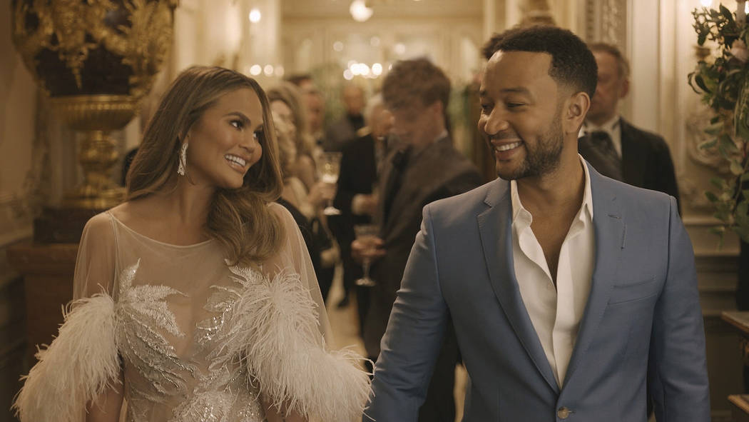 This undated image provided by Genesis shows Chrissy Teigen and her husband John Legend in a sc ...