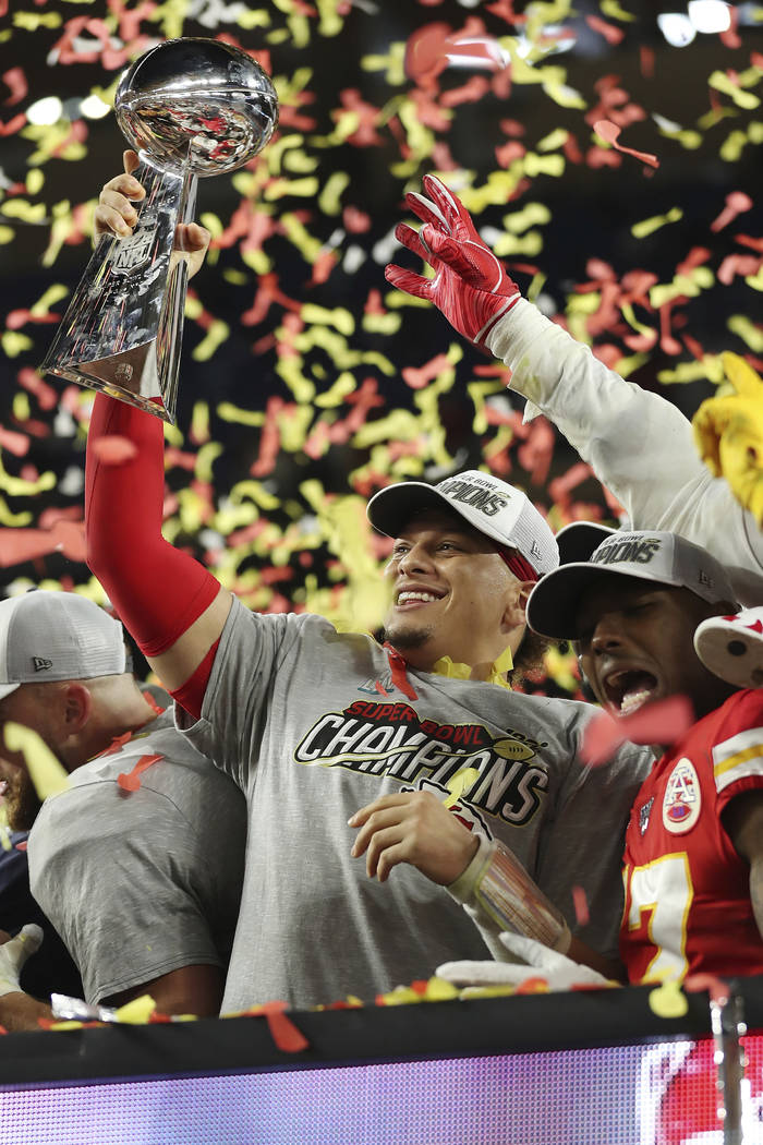 Kansas City Chiefs quarterback Patrick Mahomes (15) holds up the Vince Lombardi Trophy after th ...