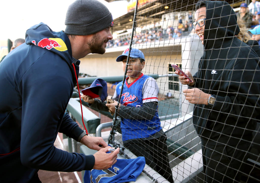 Chicago Cubs player Kris Bryant signs an autograph for Marco Valdovinos, right, 15, and Steve M ...