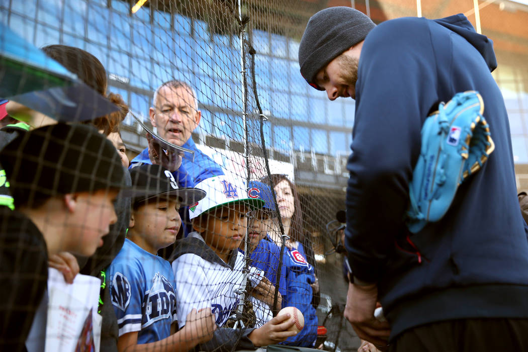 Chicago Cubs player Kris Bryant signs autographs for people during a live batting practice even ...