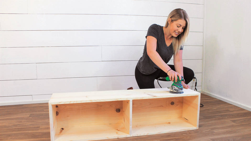 Liz Spillman uses a sander to eliminate any sharp edges, rough areas and any wood filler. (Kate ...
