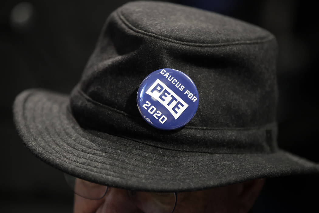 A caucus goer wears a button for Democratic presidential candidate former South Bend, Ind., May ...