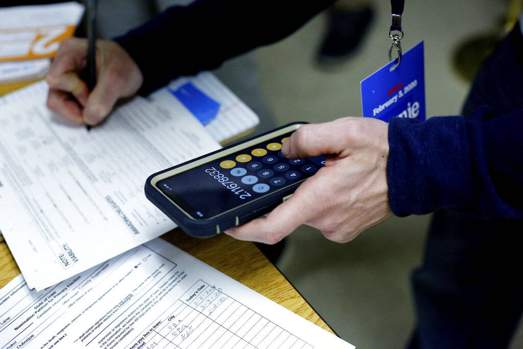 Sarah Kohles, right, helps Dorothy Schwedinger during the Democratic caucus at the UAW Hall in ...