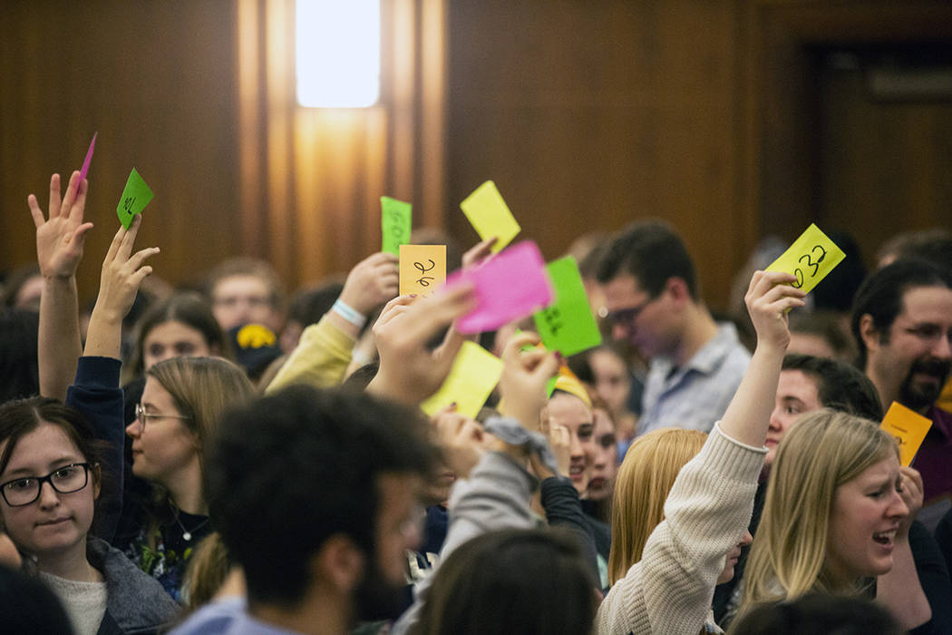 University of Iowa students hold up numbered cards while they caucus, Monday, Feb. 3, 2020, at ...