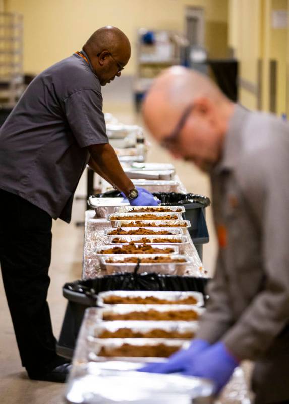 Sarif El-Amin, left, and Bob Ayouba, of Three Square food bank, package beef brisket and other ...