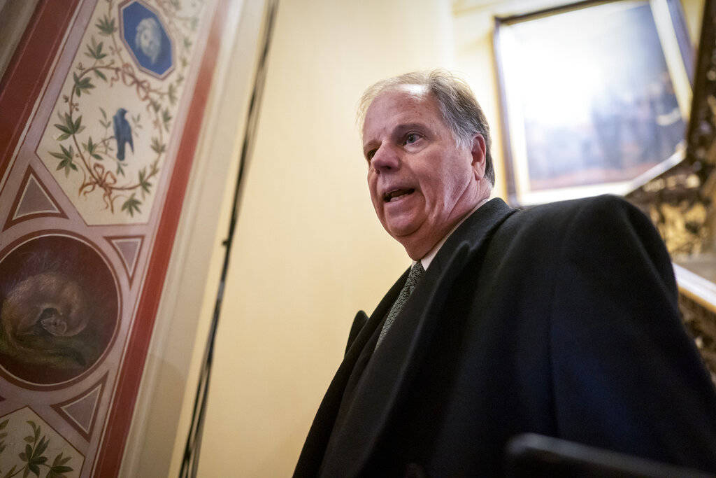 Sen. Doug Jones, D-Ala., is questioned by reporters as he arrives at the Capitol for the impeac ...