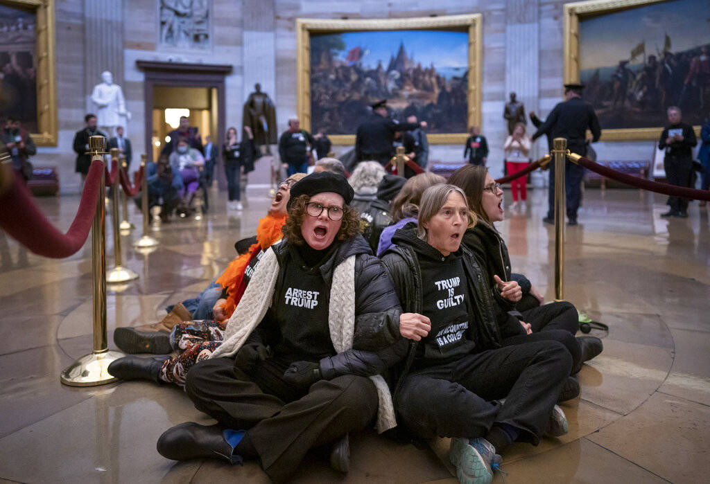 Anti-Trump protestors demonstrate in the Rotunda of the the Capitol in Washington, Wednesday, F ...