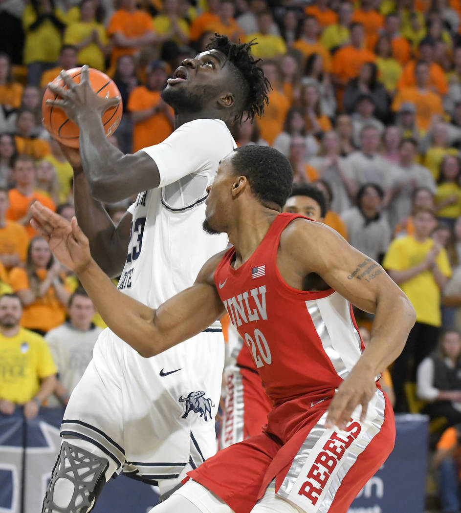 UNLV guard Bryce Hamilton (13) shoots as Utah State forward Justin Bean (34) defends during the ...