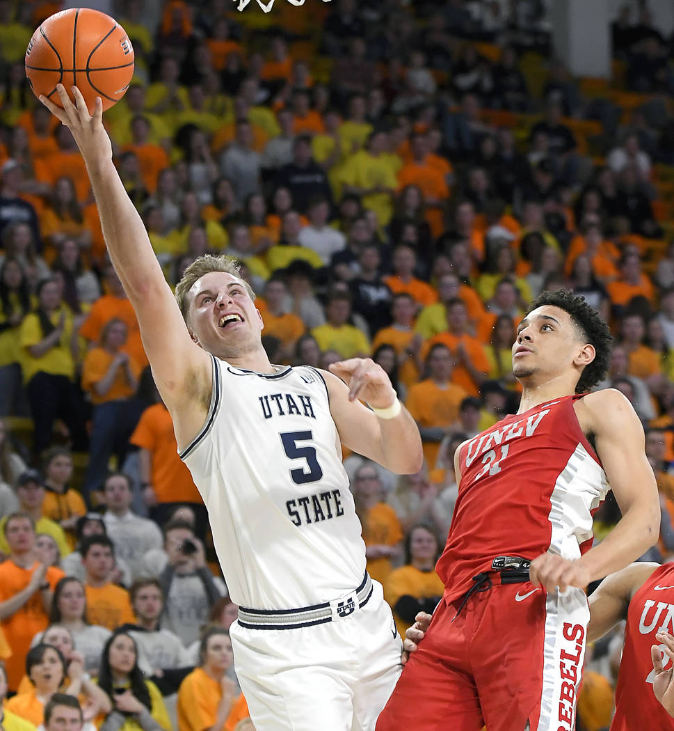 Utah State guard Sam Merrill, left, celebrates after forcing a jump ball against UNLV guard Bry ...