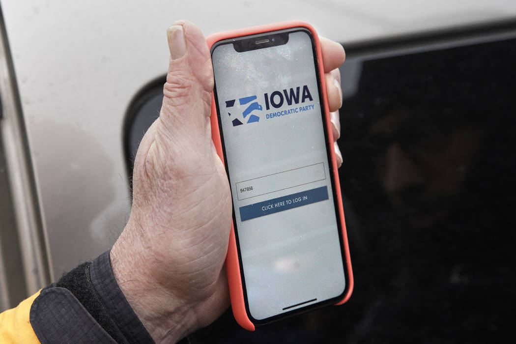 Precinct captain Carl Voss of Des Moines displays the Iowa Democratic Party caucus reporting ap ...