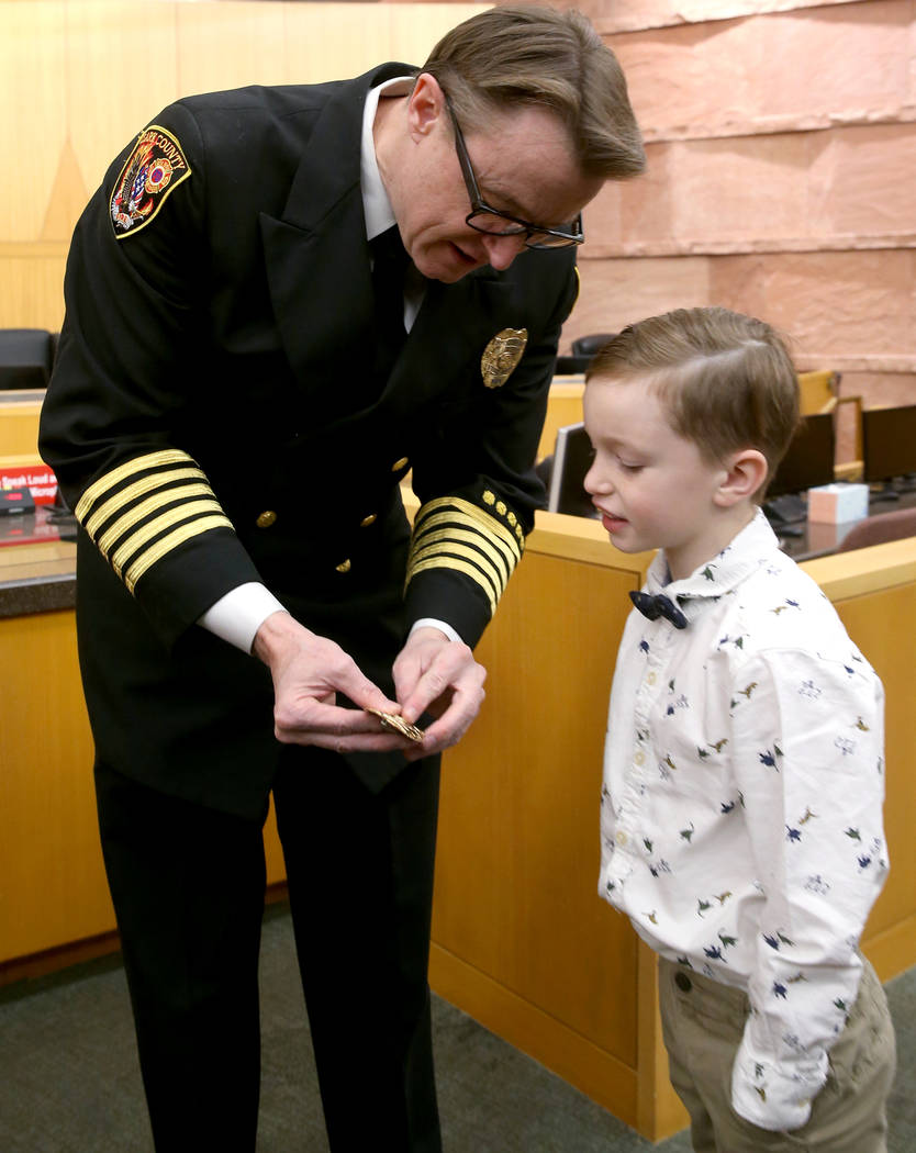 Incoming Clark County Fire Department Chief John Steinbeck shows his new badge to son Hayden, 6 ...