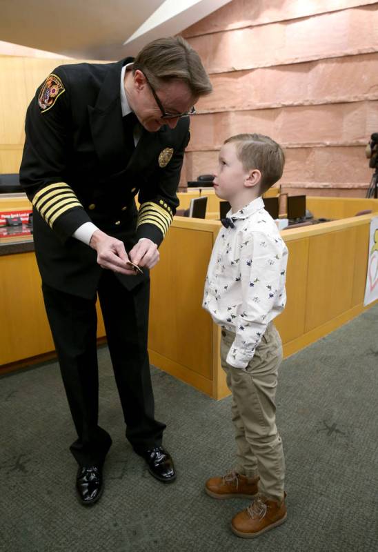 Incoming Clark County Fire Department Chief John Steinbeck shows his new badge to son Hayden, 6 ...