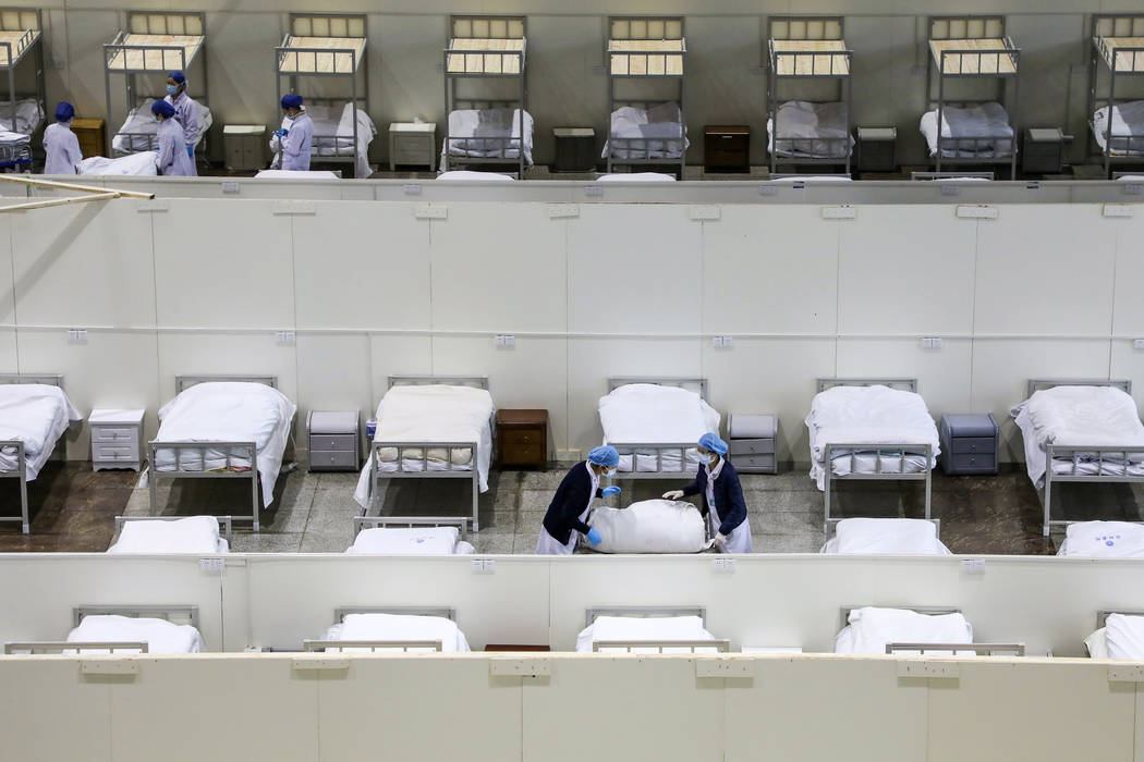 In this Wednesday, Feb. 5, 2020, photo, medical staff prepare beds at a temporary hospital whic ...